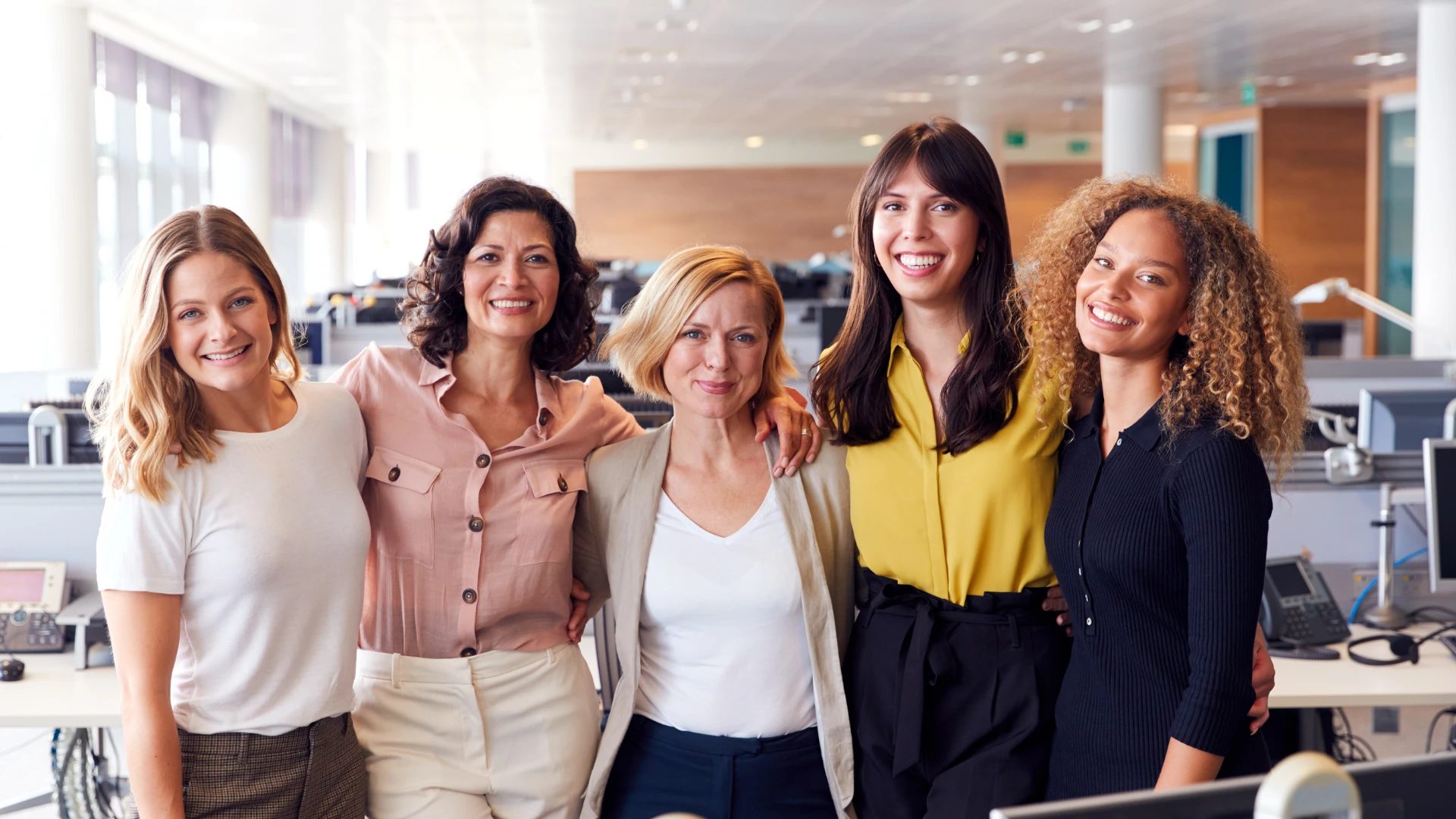 Smiling team of women colleagues in a bright office
